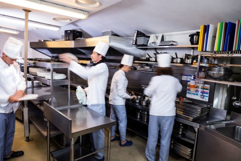 Team of chefs preparing food in the kitchen of a restaurant
