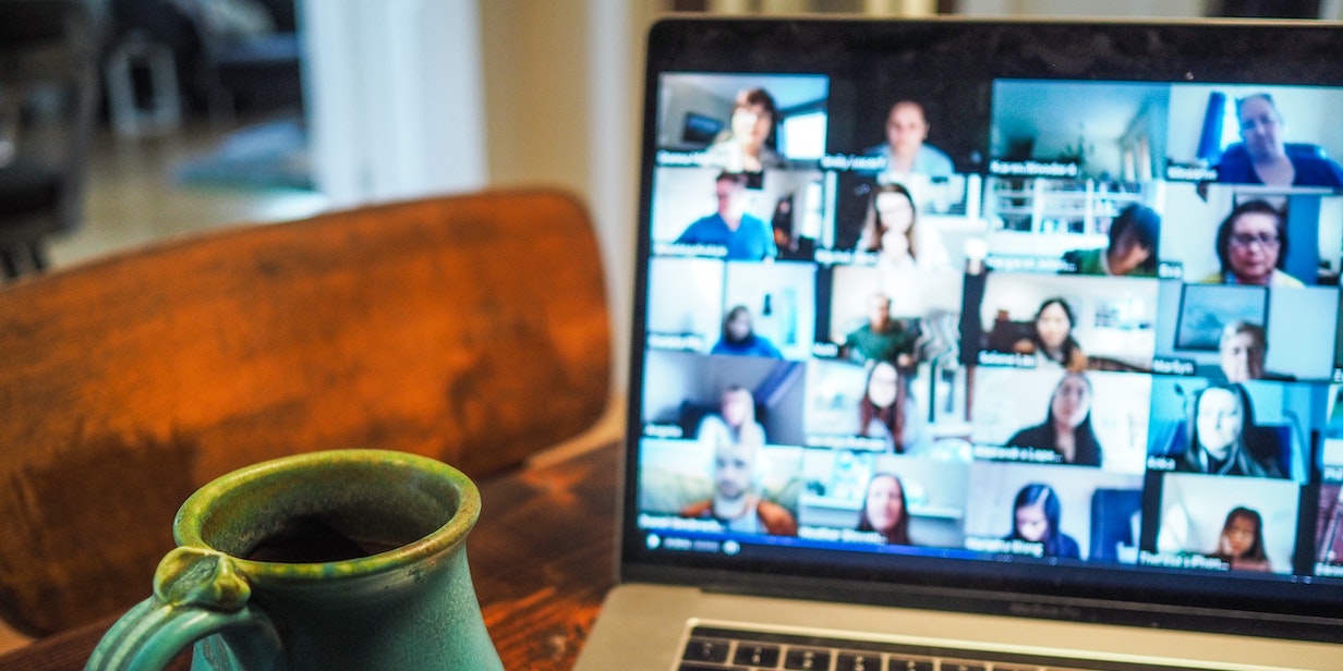 A large group video call seen on a MacBook laptop.
