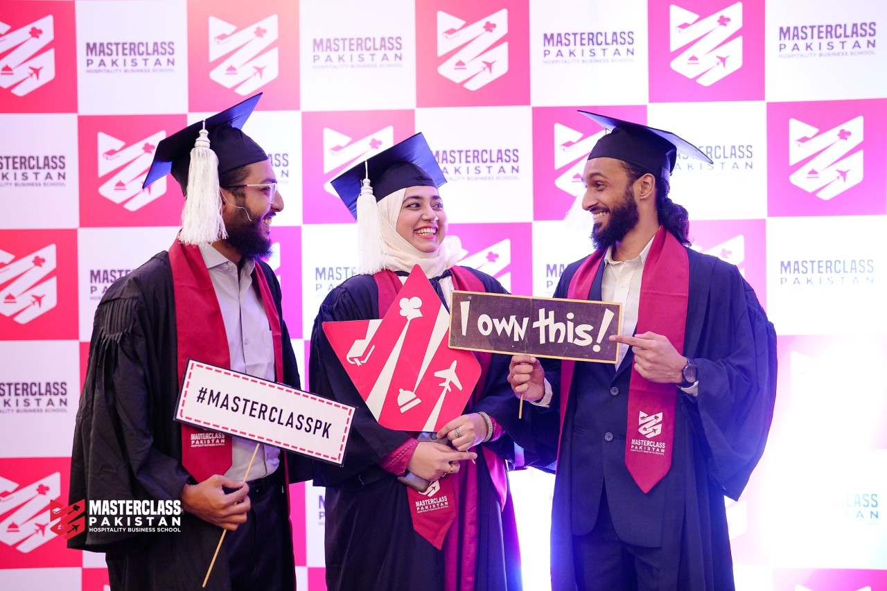 MasterClass Pakistan graduates laughing and celebrating while holding signs at the Annual Convocation 2022.
